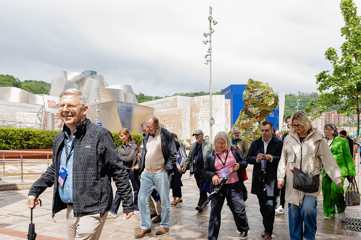 Asistentes al IMCC InFocus Bilbao 2026 paseando frente al Guggenheim Bilbao y el Puppy de Jeff Koons