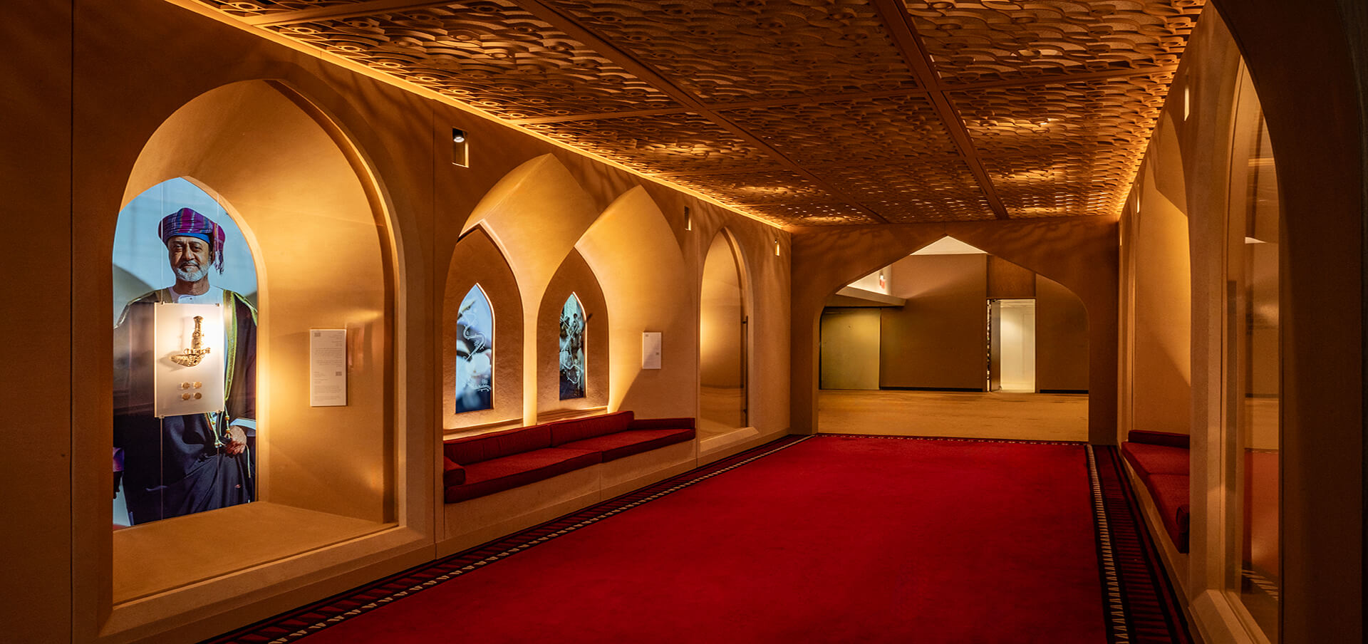 Corredor Omán ONU Nueva York — nichos arqueados con pantallas y piezas culturales de Omán. Producción museográfica de Proasur