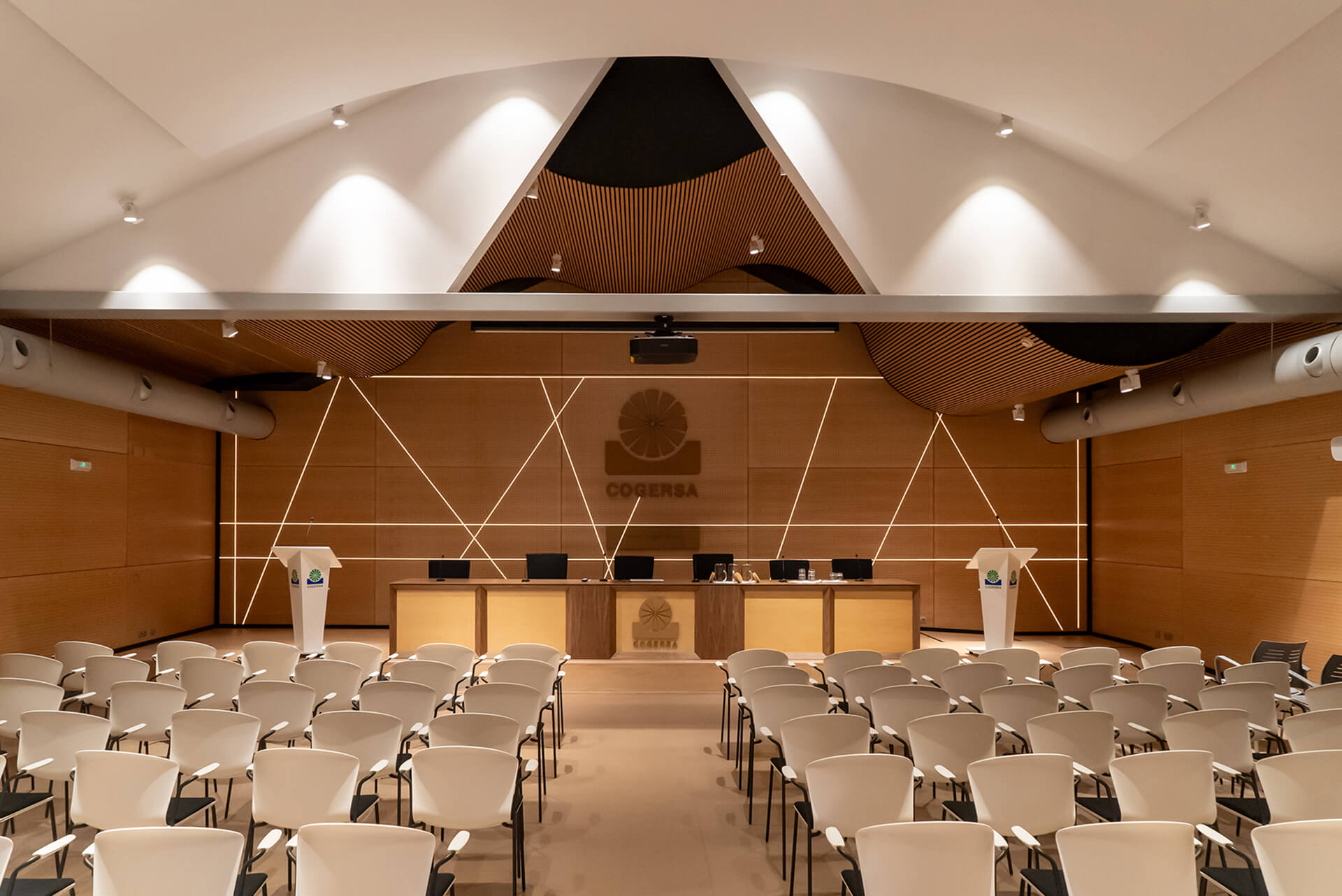 Sala de actos del Centro de Interpretación de Residuos COGERSA con diseño en madera y líneas de luz
