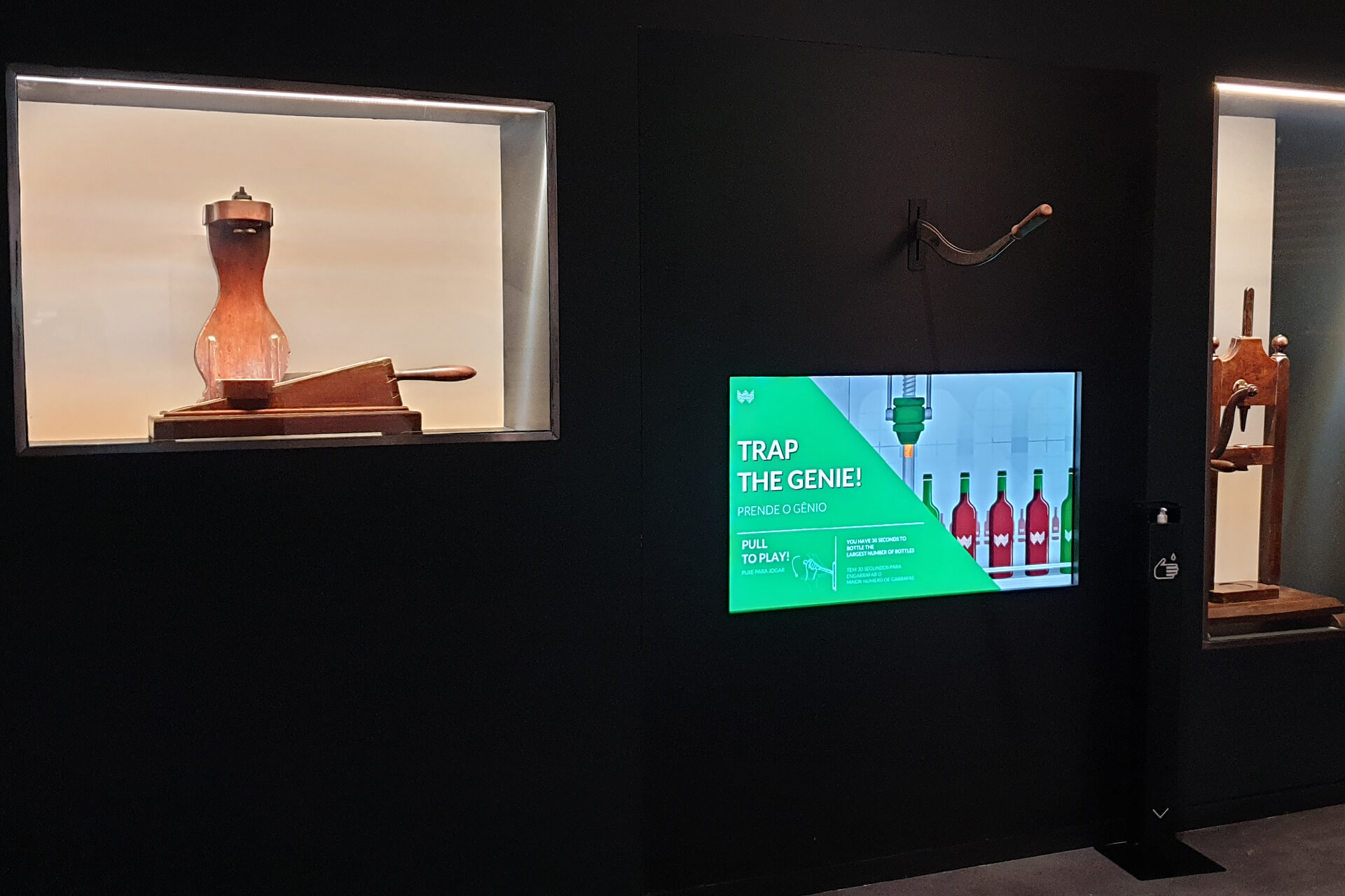 Pantalla del interactivo Trap de Genie con palanca integrada en pared, mostrando el juego de embotellado en Planet Cork, WOW Porto