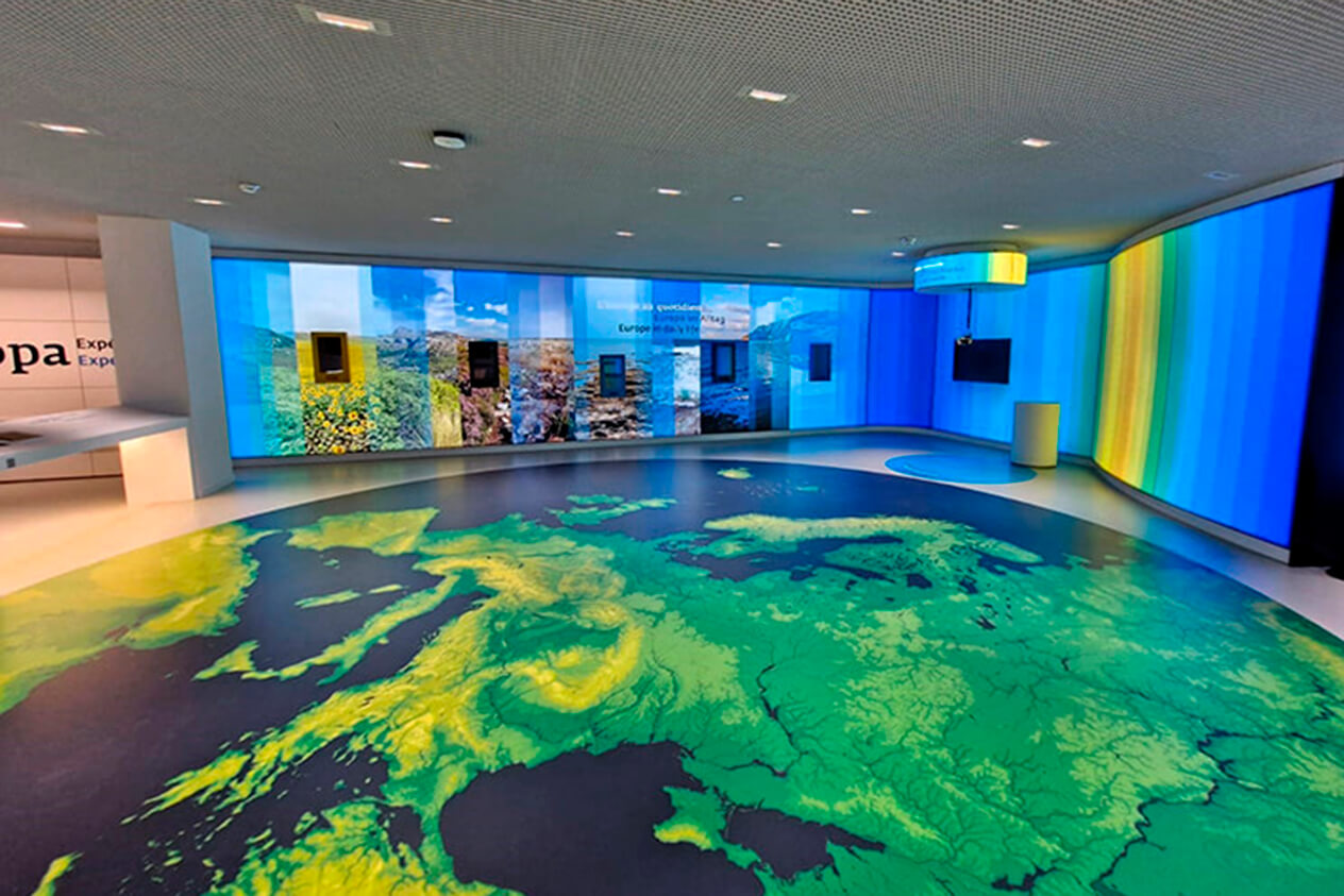 Sala con mapa en el suelo y pared de rayas de color en Luxemburgo
