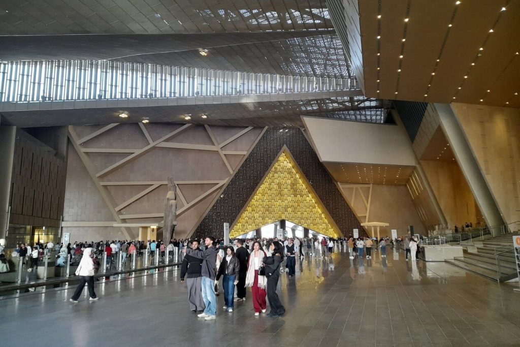Triángulo dorado de acceso al Grand Egyptian Museum con visitantes
